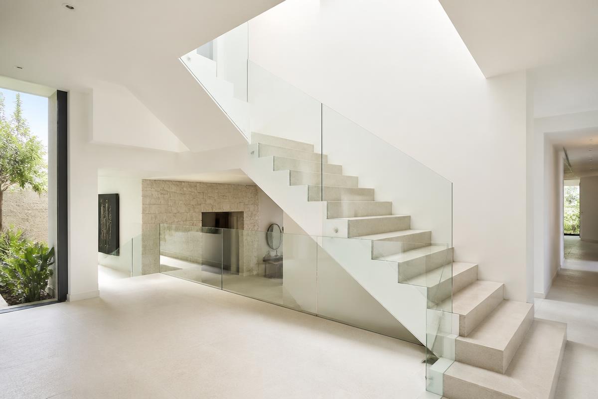 Interior staircase with frameless glass railing in a Coral Gables villa